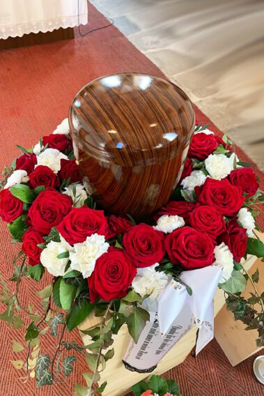 Urnenkranz mit roten Rosen und weißen Nelken