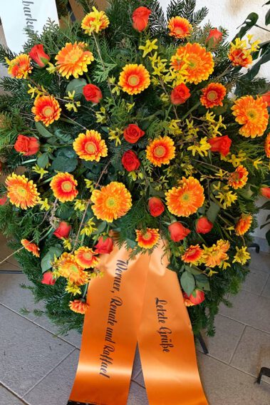 Trauerkranz mit orangen Blumen