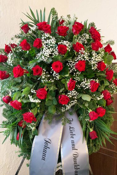 Trauerkranz mit roten Rosen