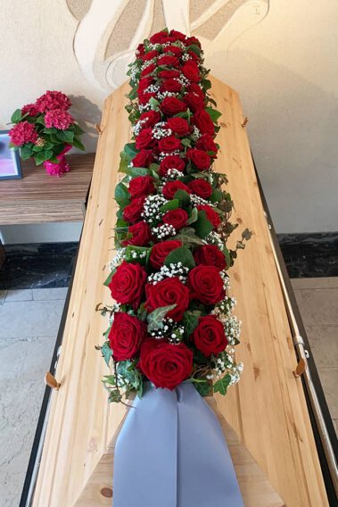 Sarggesteck mit roten Rosen