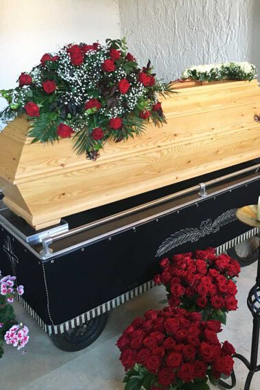 Sarggesteck mit roten Rosen